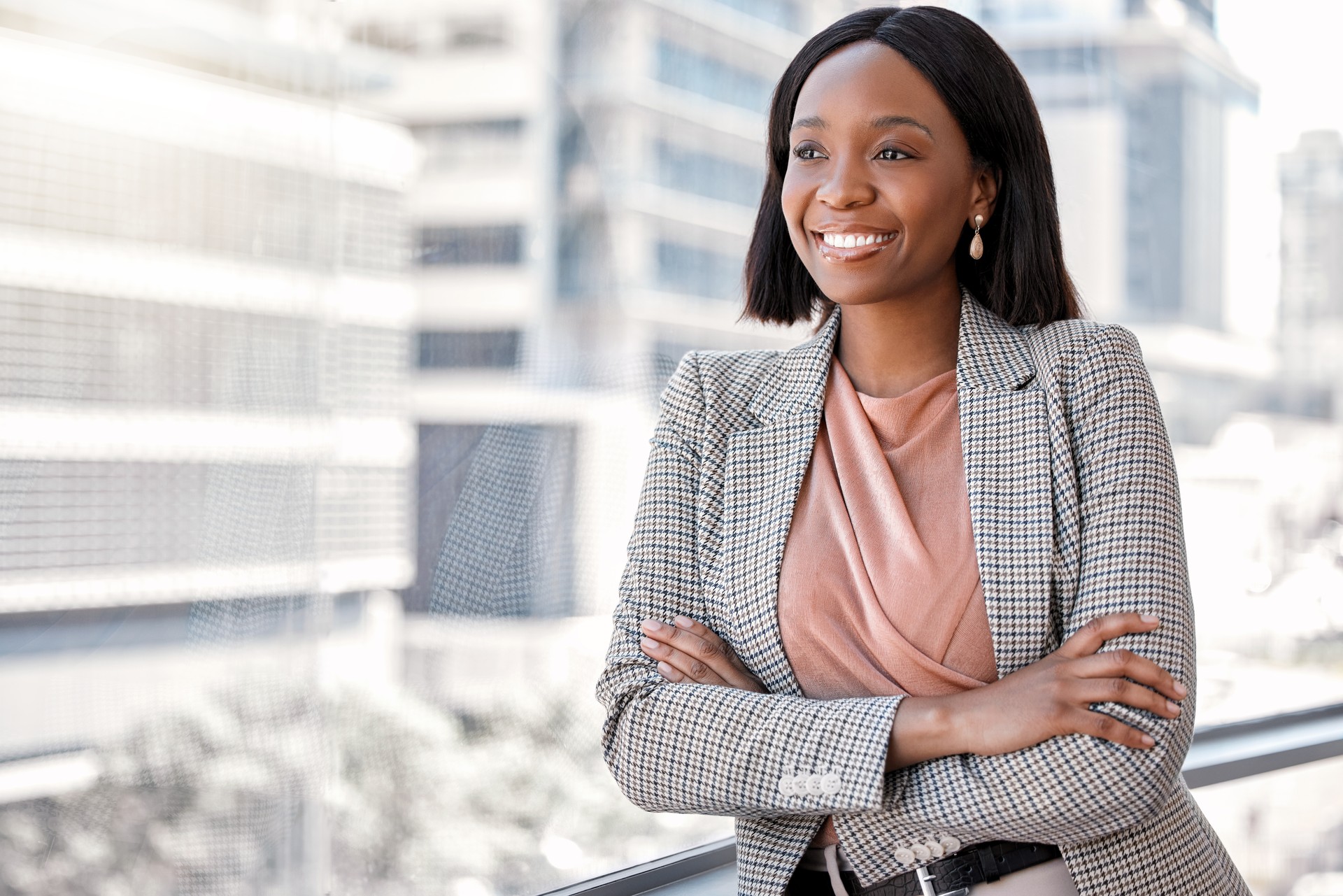 Shot of a confident young businesswoman leaning against a window